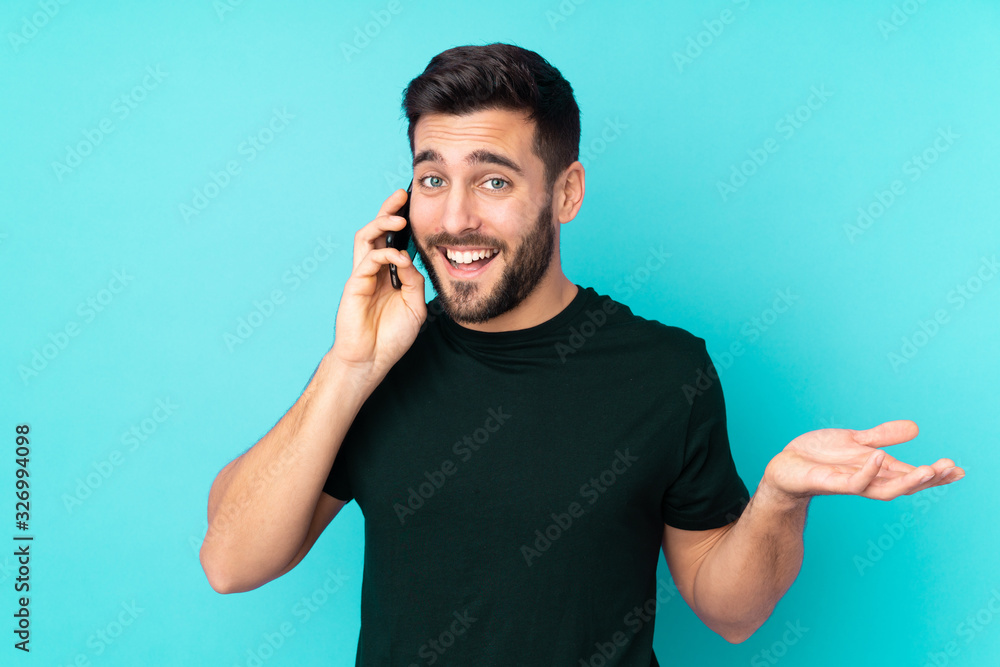 Caucasian handsome man isolated on blue background keeping a conversation with the mobile phone with someone Caucasian handsome man isolated on blue background keeping a conversation with the mobile phone with someone