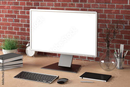 Workspace with blank computer monitor white screen mock up on the wooden desk near red brick wall. 3d illustration