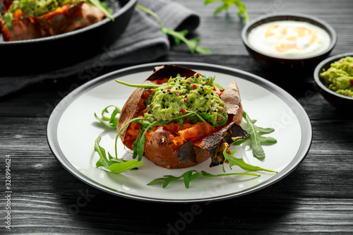Baked Sweet potato boats stuffed with avocado guacamole and wild rocket sprinkled with nigella seeds