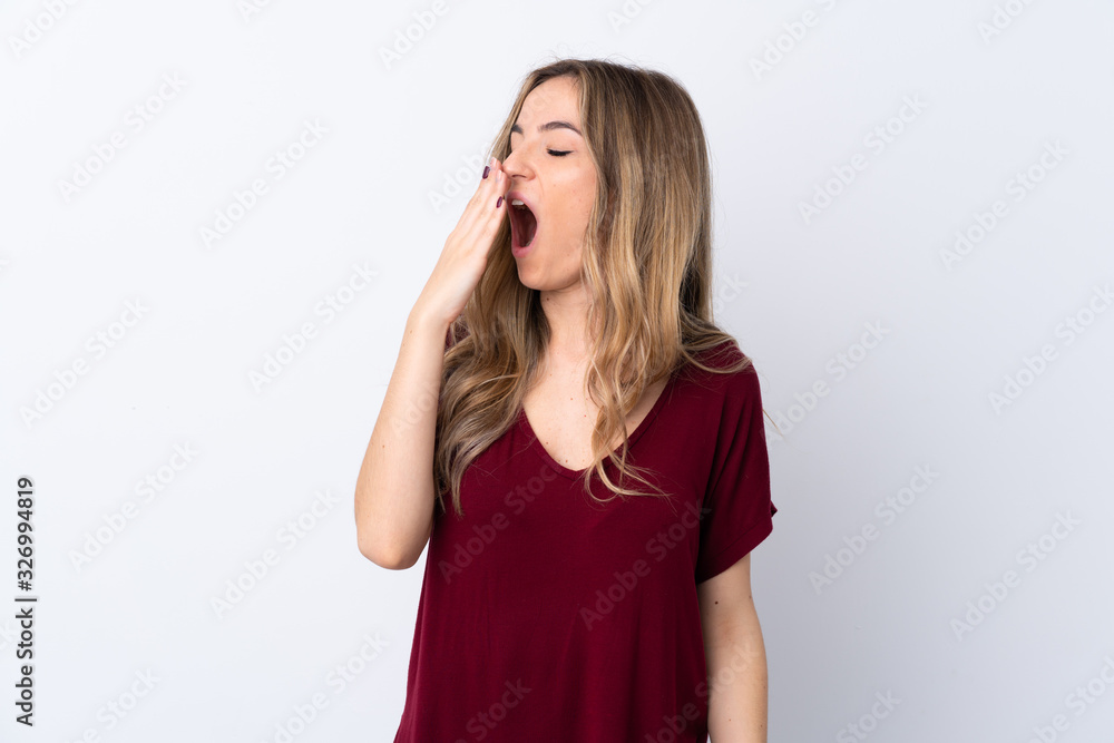 Young woman over isolated white background yawning and covering wide open mouth with hand Young woman over isolated white background yawning and covering wide open mouth with hand