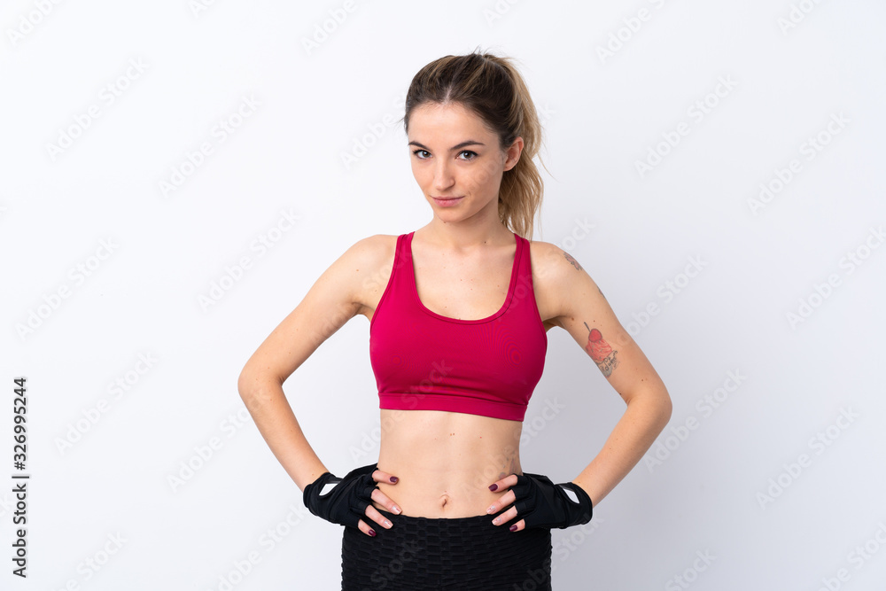 Young sport woman over isolated white background posing with arms at hip