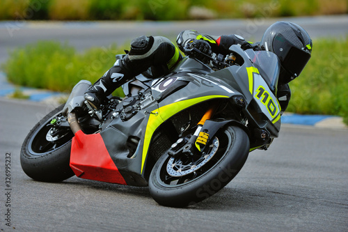 Motorcycle practice leaning into a fast corner on track