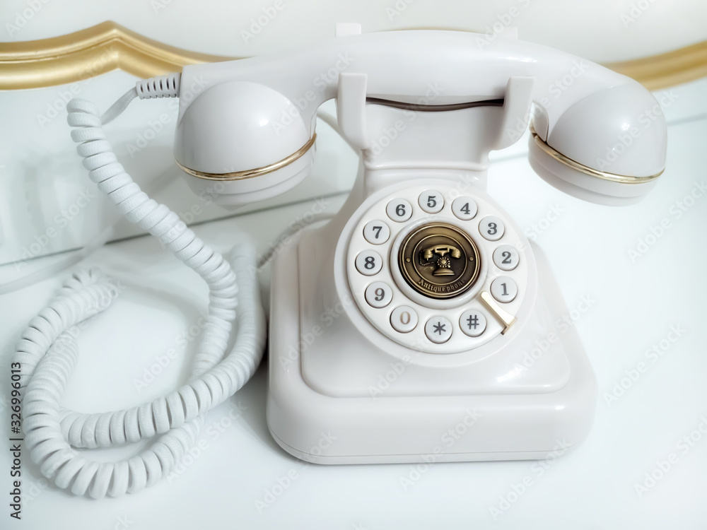 Old white telephone with rotary disc on white background Old white telephone with rotary disc on white background