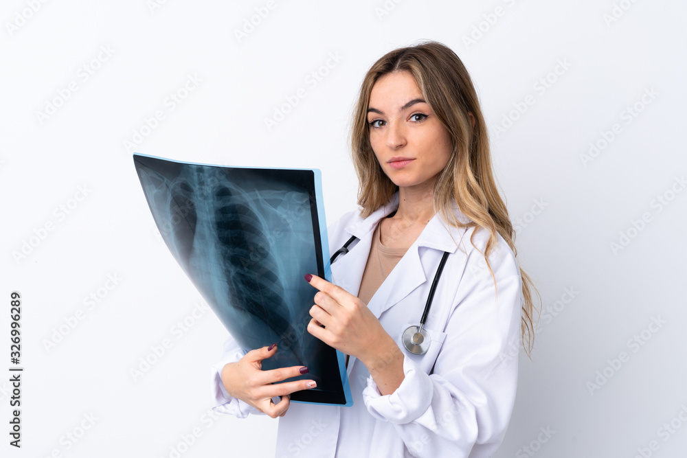 Young woman over isolated white background wearing a doctor gown and holding a bone scan Young woman over isolated white background wearing a doctor gown and holding a bone scan