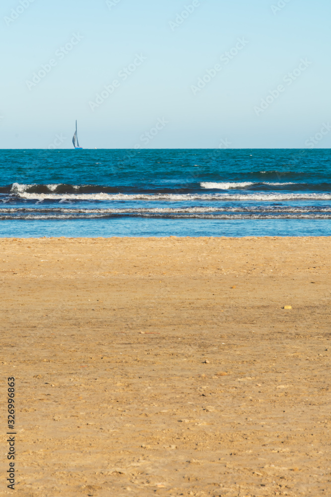 Valencia Beach (Malvarrosa.) with waves and ships in the background