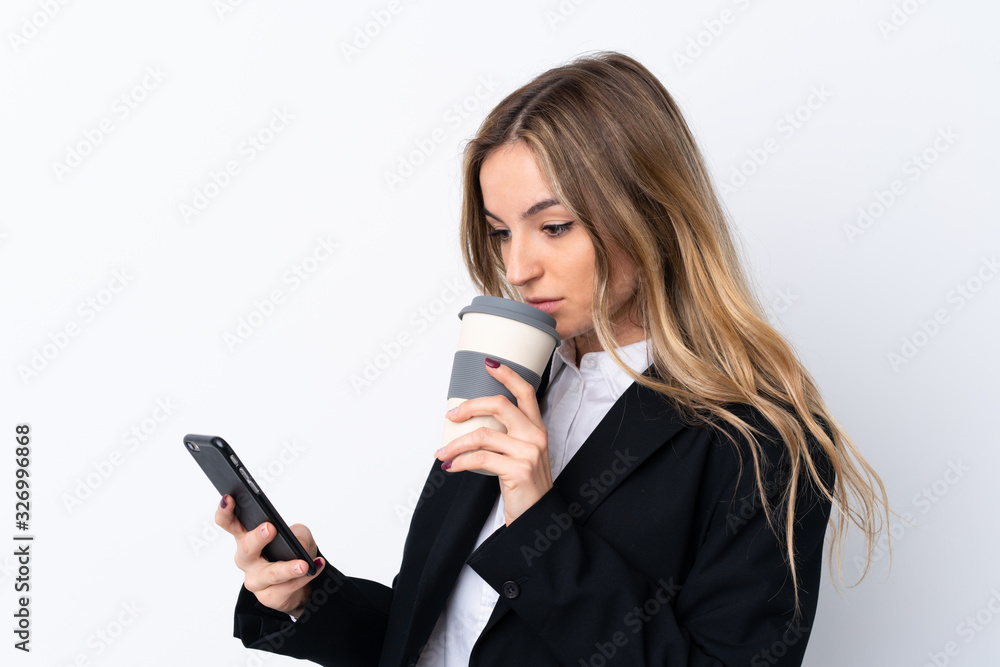Young business woman over isolated white background holding a cup of coffee and a phone Young business woman over isolated white background holding a cup of coffee and a phone