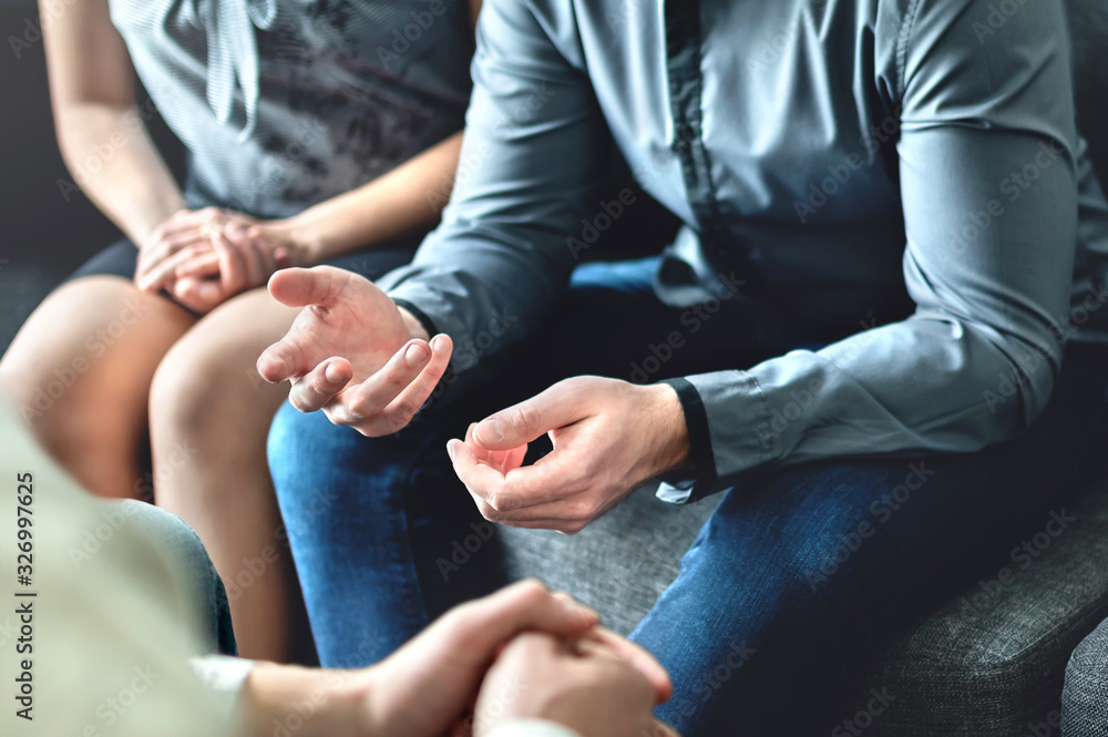 Fototapeta premium Couple counseling or therapy session. Man talking about problems in the family. Husband and wife meeting their psychiatrist. Discussion with marriage counselor, mediator or relationship psychologist.