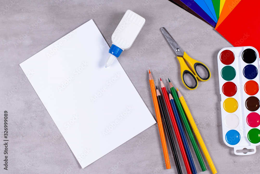 Sheets of paper, glue and scissors on a table Sheets of paper, glue and scissors on a table