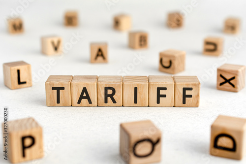 Tariff - words from wooden blocks with letters, a tax on imports or exports tariff concept, white background photo