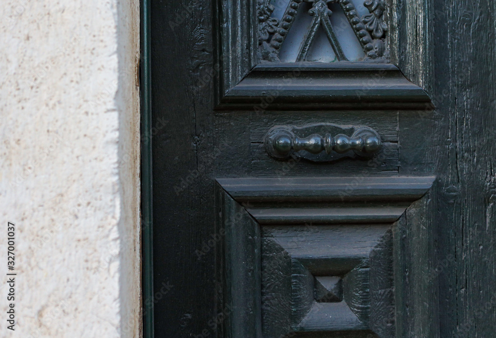 Wooden dark aged textured entrance with rings door handles and metal details. Architecture background. Old wooden door with rivets and aged metal door handle Wooden dark aged textured entrance with rings door handles and metal details. Architecture background. Old wooden door with rivets and aged metal door handle
