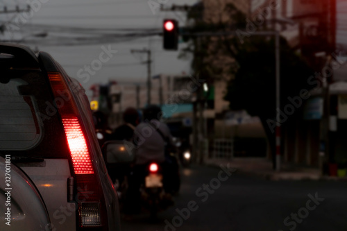 Blurred image of cars on the road with light break at in evening and traffic red light in the city.