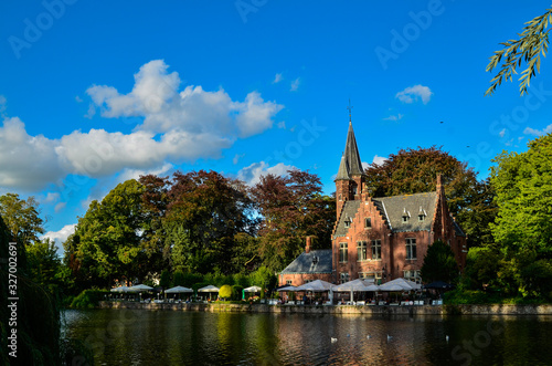 Bruges, Belgium. August 2019. The lake and minnewater park are the most romantic place. The body of water on which the red brick castle and the large trees with green foliage are reflected. © Massimo Parisi