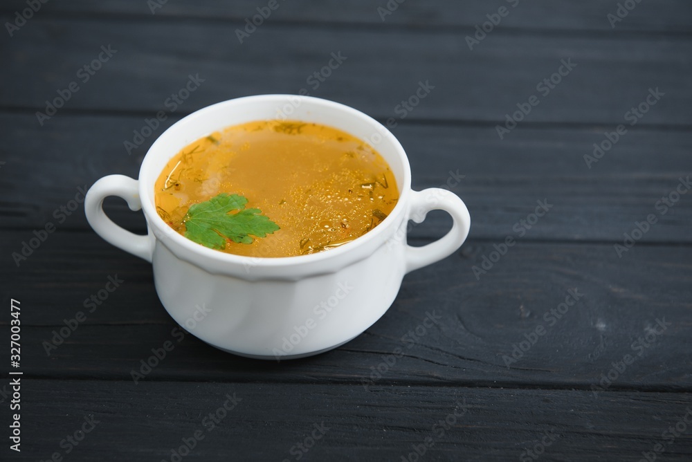 A picture of a bowl of traditional chicken soup served in a bowl over wooden background A picture of a bowl of traditional chicken soup served in a bowl over wooden background