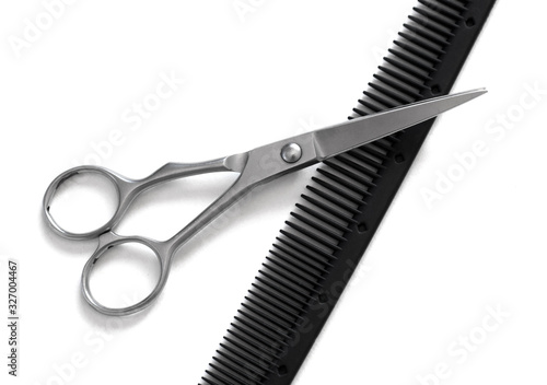 hairdresser professional scissors and black hairbrush comb isolated on white background close up