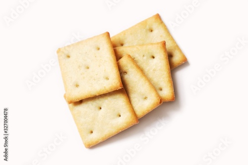 Square crispy saltine crackers isolated on white background. Flat lay food photography