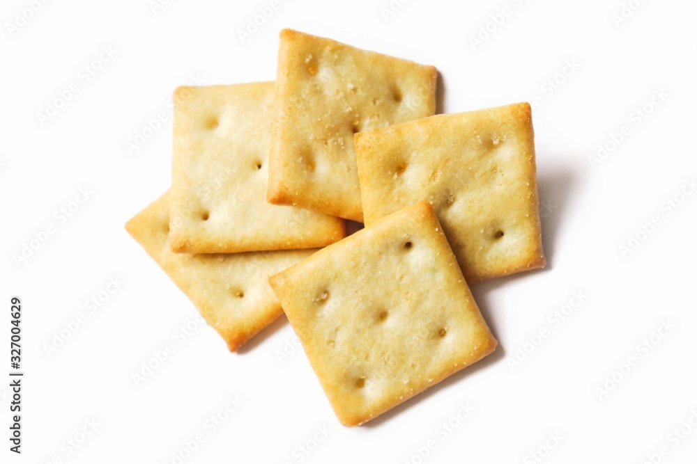 Crispy salty cracker on a white background. Flat lay food photography Crispy salty cracker on a white background. Flat lay food photography