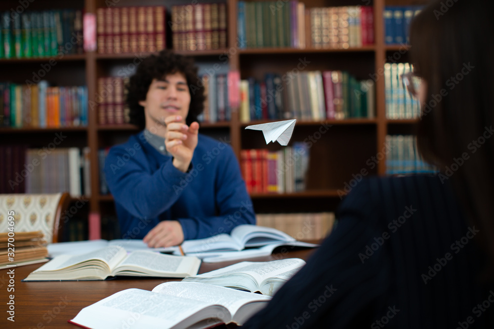 Student in the library launches a paper airplane Student in the library launches a paper airplane
