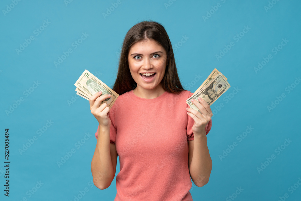 Young woman over isolated blue background taking a lot of money Young woman over isolated blue background taking a lot of money