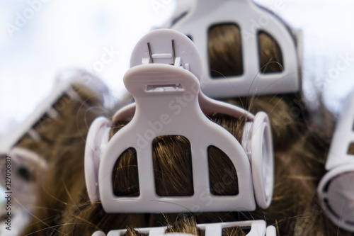 Curling rollers in a woman's hair. Hair curlers on the girl's head close up