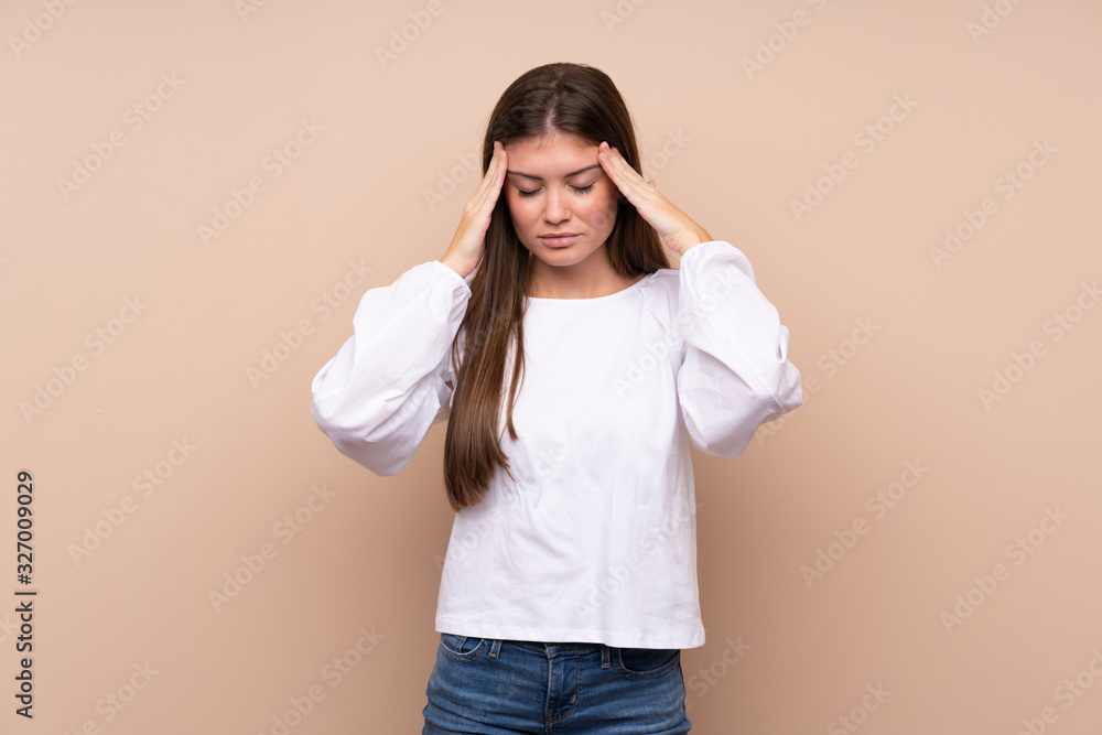 Young girl over isolated background with headache Young girl over isolated background with headache