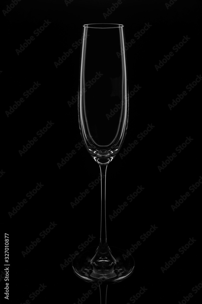 Empty champagne glass on a black background, elegantly illuminated on the sides. Concept, mysterious club life.