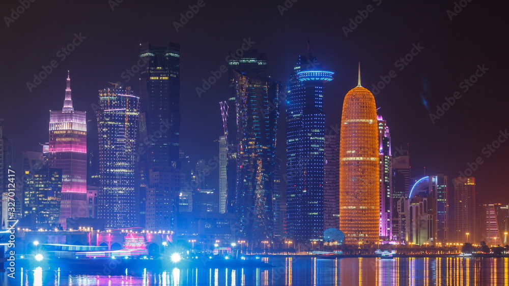 Traditional dhow boat in Doha at night timelapse, with modern buildings in the