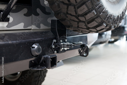 Fotografi Close-up on a new black tow hitch installed on a offroad car with an iron black bumper in a vehicle repair shop