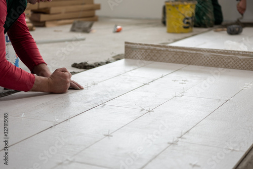 worker installing the ceramic wood effect tiles on the floor
