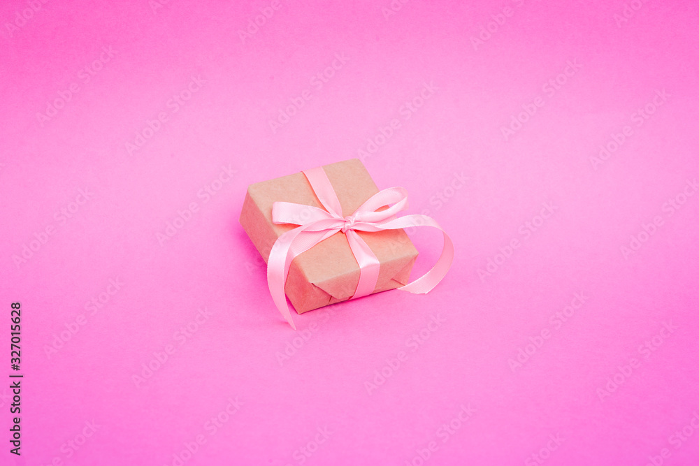 Gift wrapped in parchment, eco paper, kraft paper on a pink background. Gift wrapped in parchment, eco paper, kraft paper on a pink background.