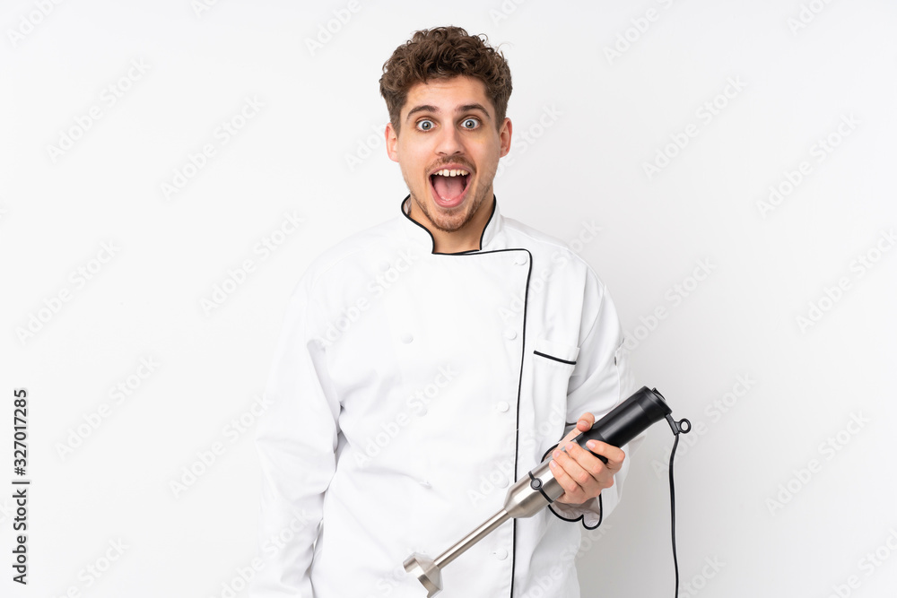 Man using hand blender isolated on white background with surprise facial expression Man using hand blender isolated on white background with surprise facial expression