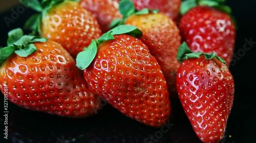 Wallpaper Mural macro view group of whole fresh juicy red strawberries lie on black background Torontodigital.ca