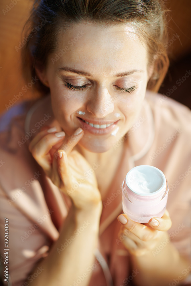happy woman with jar applying lip contour cream