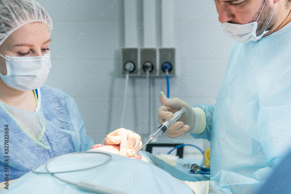 Doctor making injection during facial surgery operation Doctor making injection during facial surgery operation
