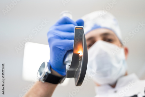 Unfocused doctor holding intubation equipment over patient (view from the patient) photo