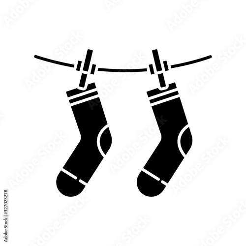 Outside drying black glyph icon. Laundry, clothesline, outdoors clothes drying. Socks hanging on clothesline, washed garment. Silhouette symbol on white space. Vector isolated illustration