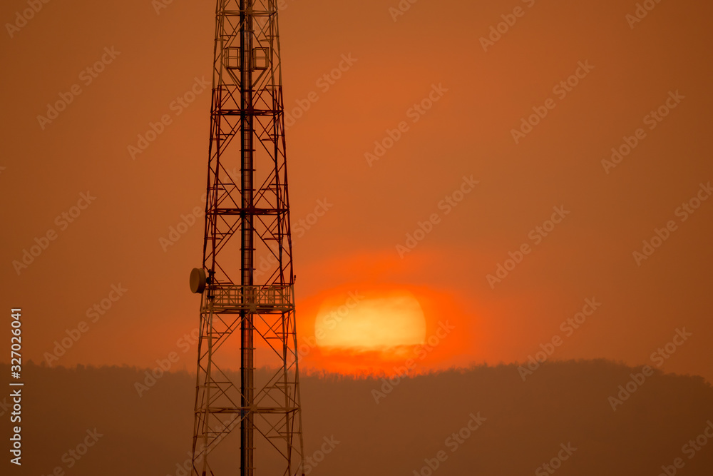 Telecom communication concept, communication construction pole on sihouette sunset on golden sky and cloud background, beautiful sunshine big red sun over hills in twilight for graphic creative design
