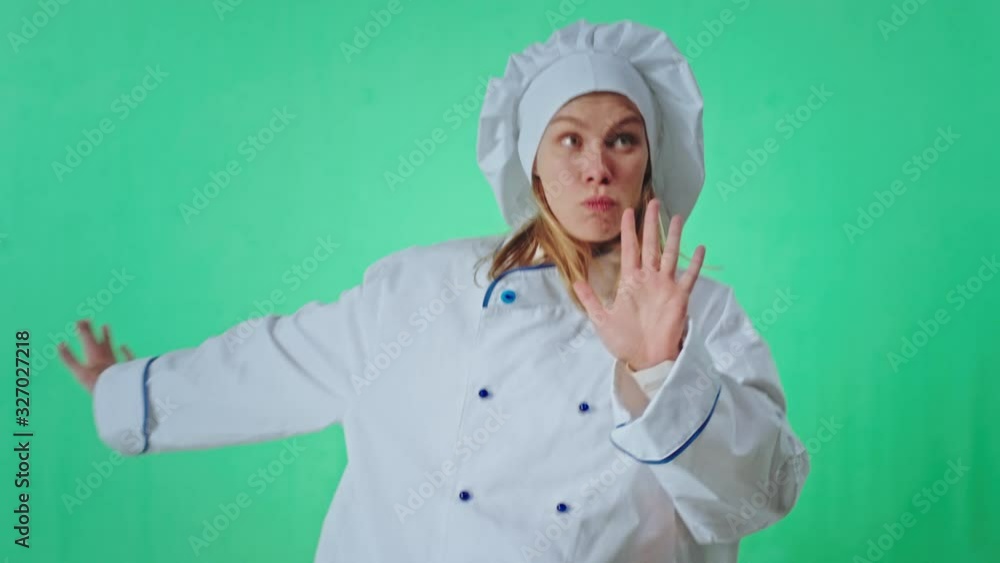 Dancing baker woman in the uniform on the green background studio she moving very funny and excited looking straight to the camera Dancing baker woman in the uniform on the green background studio she moving very funny and excited looking straight to the camera