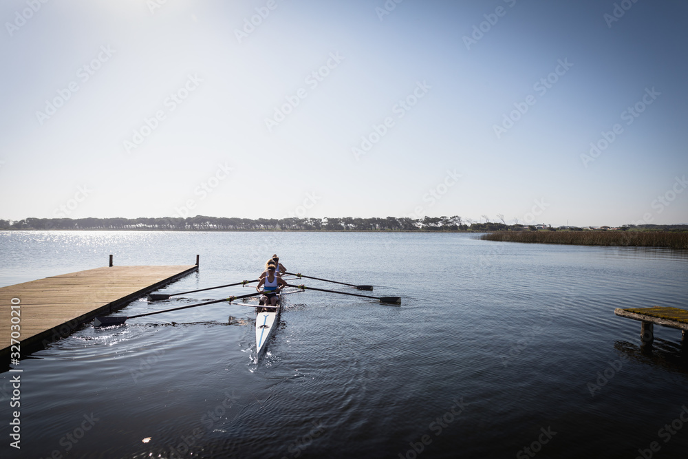 Female rowing team training on a river Female rowing team training on a river
