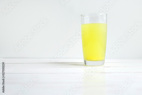 Glass of water with dissolved healthy vitamin tablet on white with copyspace
