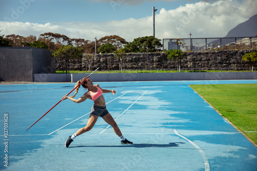 Athlete throwing a javelin at the stadium photo