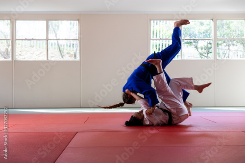 Judokas practicing judo during a sparring in a gym photo