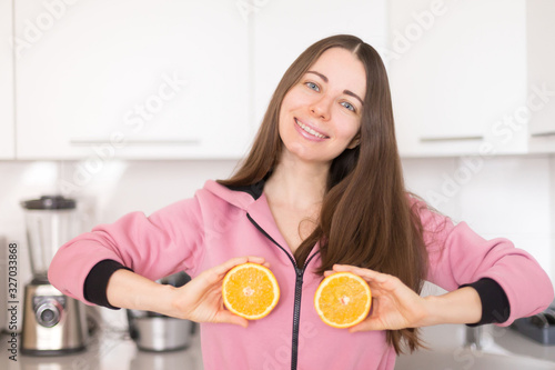  woman in pink overalls, kitchen, orange fruit