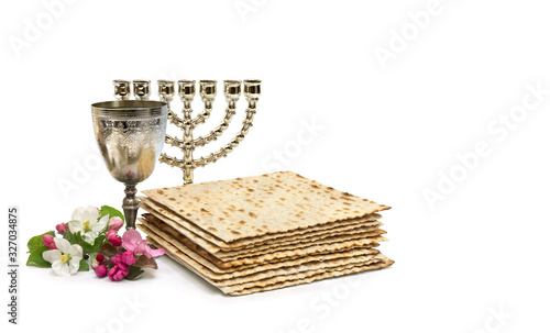 Matzo, wine, menorah and pink flowers apple tree for passover celebration on white background with space for text photo