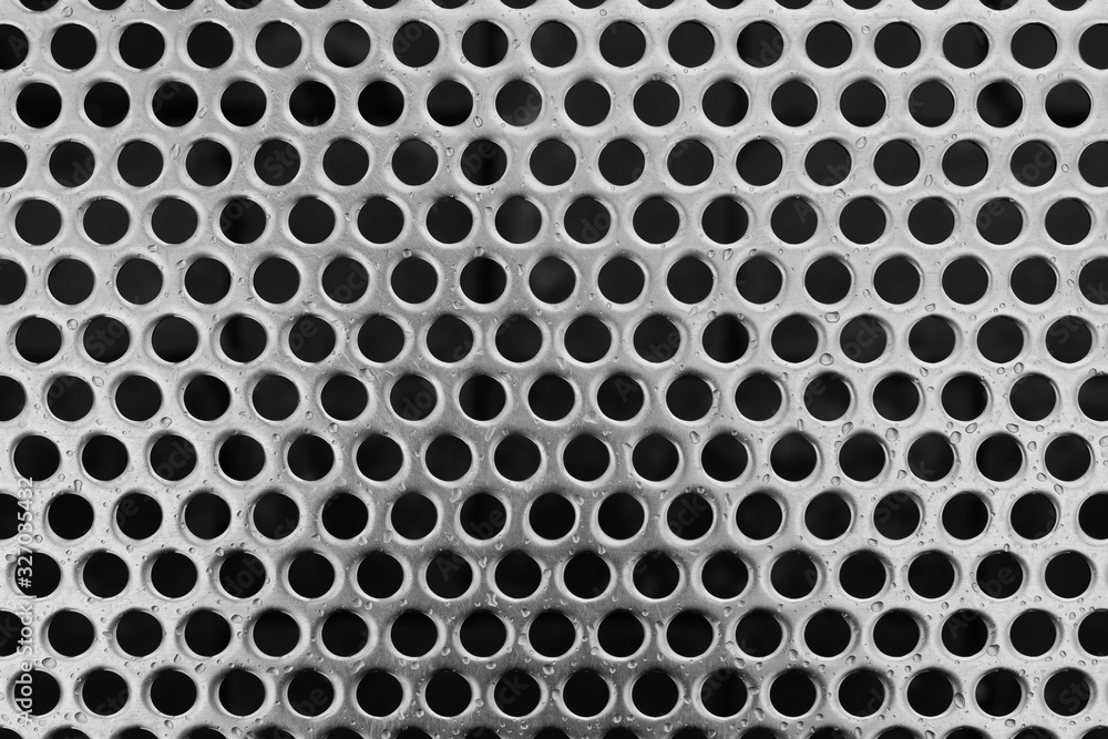 Closeup of stainless metal bench texture surface with holes and with raindrops Closeup of stainless metal bench texture surface with holes and with raindrops