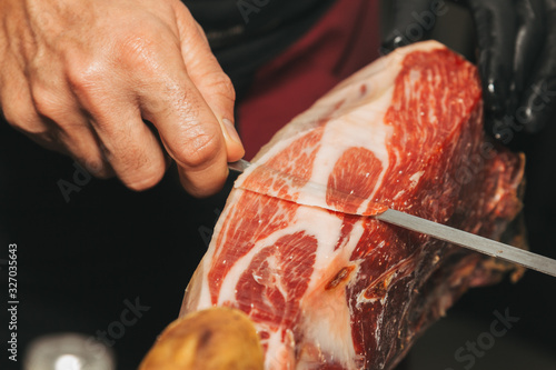 Foto Stock photo of a hand of a master iberian ham cutter
