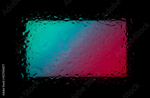 Colored abstract wallpaper on a black background with raindrops on glass