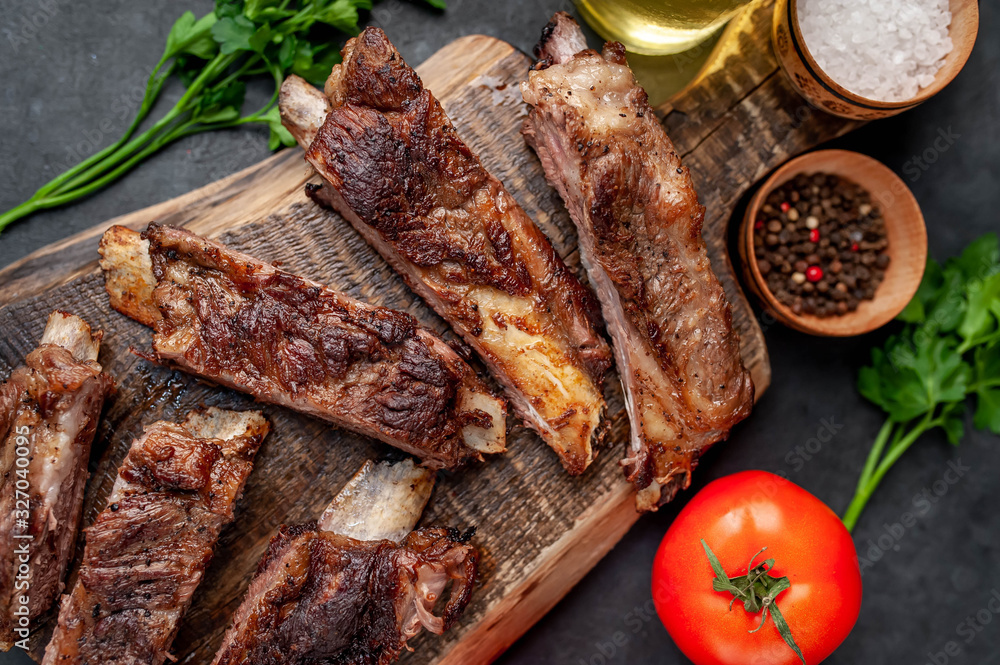 pork ribs with spices, tomatoes and herbs on a stone background pork ribs with spices, tomatoes and herbs on a stone background