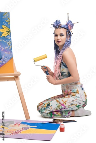 Sexy girl with brush sitting near easel view photo