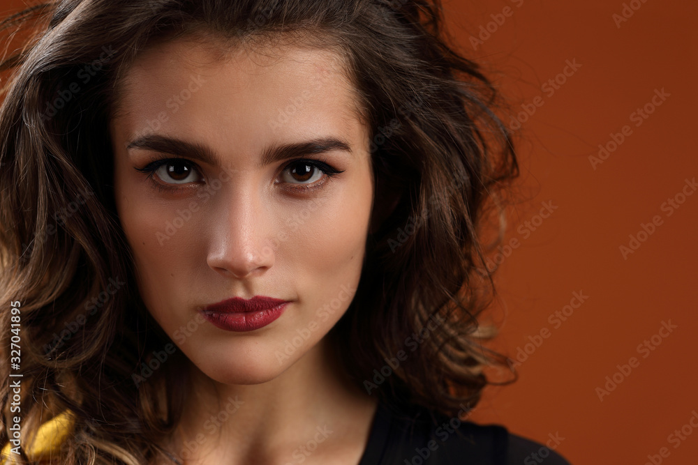 Fototapeta premium Portrait of a beautiful girl on a brown background