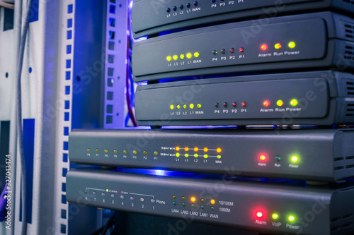 Communication equipment for voice Internet connection. Network gateways for ip telephony work in the server room in the dark. Color indication on the interfaces of office telephone routers.